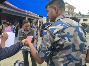 Captain Dam Bahadur Garbuja Pun handing out clothes to victims