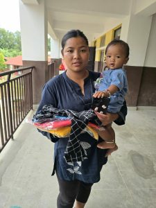 Mother with her baby receiving clothing for both